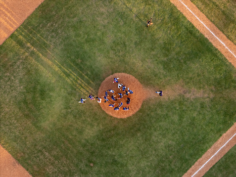 Aerial view of a baseball game in progress on a dirt mound and green grass field in Santo Domingo Distrito Nacional Dominican Republic.
