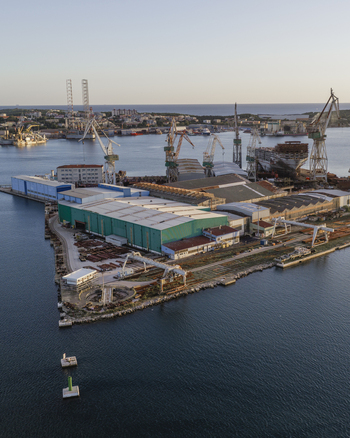 Aerial view of Pola Port shipyard with large cranes industrial buildings and ships under construction along the Adriatic Sea coastline in Pula Istarska zupanija Croatia. Aerial view of Pola Port shipyard with large cranes industrial buildings and ships under construction along the Adriatic Sea coastline in Pula Istarska zupanija Croatia.