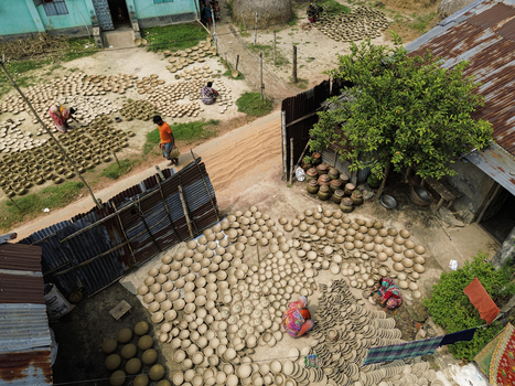 Joypurhat Bangladesh 28 September 2026 Aerial view of local artisans drying handmade clay pottery in the sun with numerous bowls spread across the ground in a rural village setting. Joypurhat Bangladesh 28 September 2026 Aerial view of local artisans drying handmade clay pottery in the sun with numerous bowls spread across the ground in a rural village setting.