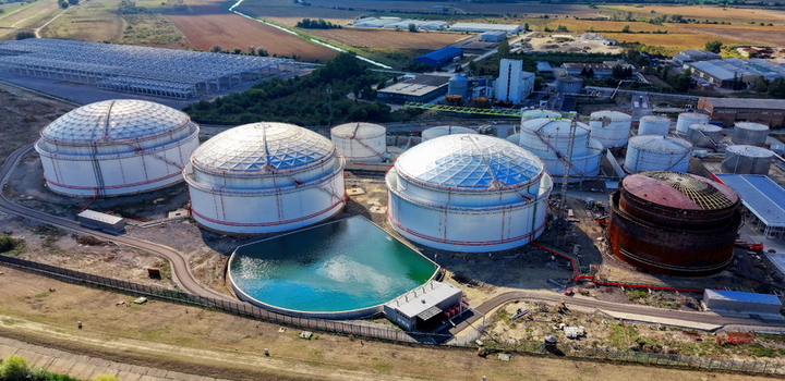 Aerial view of fuel tanks at an industrial facility with large storage tanks a circular water reservoir and surrounding fields in Kovin Vojvodina Serbia. Aerial view of fuel tanks at an industrial facility with large storage tanks a circular water reservoir and surrounding fields in Kovin Vojvodina Serbia.