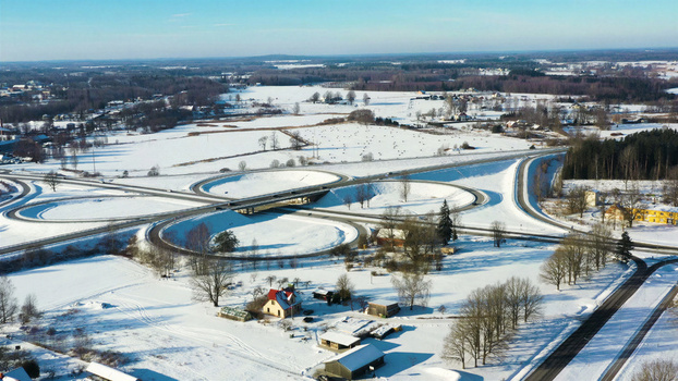 Aerial view of a highway interchange surrounded by snow covered fields and rural landscape in Latvija. Aerial view of a highway interchange surrounded by snow covered fields and rural landscape in Latvija.