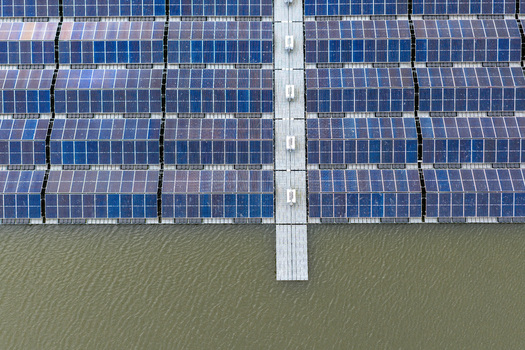 Aerial view of rows of floating solar panels on a water surface with central walkways and symmetrical patterns Beilen Drenthe Netherlands. Aerial view of rows of floating solar panels on a water surface with central walkways and symmetrical patterns Beilen Drenthe Netherlands.
