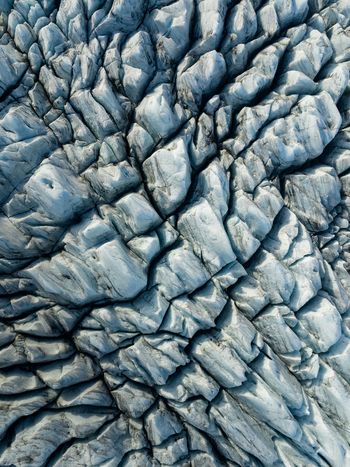 Aerial view of intricate glacial patterns etched into the ice a symphony of blue and grey revealing the raw beauty of nature s artistry Fjallsarlon Sveitarfélagið Hornafjörður Iceland. Aerial view of intricate glacial patterns etched into the ice a symphony of blue and grey revealing the raw beauty of nature s artistry Fjallsarlon Sveitarfélagið Hornafjörður Iceland.