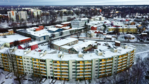 Aerial view of residential apartment buildings covered in snow during winter with surrounding urban infrastructure and trees in Latvia. Aerial view of residential apartment buildings covered in snow during winter with surrounding urban infrastructure and trees in Latvia.