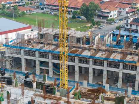 Bukit Tambun Penang Malaysia 25 September 2026 Aerial view of a construction area featuring a tall yellow crane concrete pillars steel reinforcement bars and surrounding residential buildings. Bukit Tambun Penang Malaysia 25 September 2026 Aerial view of a construction area featuring a tall yellow crane concrete pillars steel reinforcement bars and surrounding residential buildings.