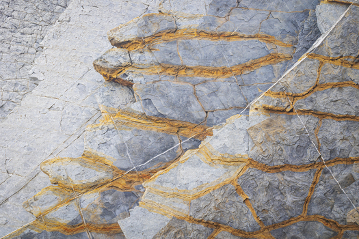 View of the unique geological rock formations with orange mineral veins at Playa de Sopelana in Vizcaya Pais Vasco Spain. View of the unique geological rock formations with orange mineral veins at Playa de Sopelana in Vizcaya Pais Vasco Spain.