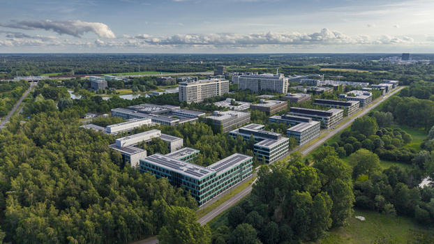 Aerial view of High Tech Campus Eindhoven featuring modern office buildings surrounded by lush green forests and landscaped grounds in Eindhoven Noord Brabant Netherlands. Aerial view of High Tech Campus Eindhoven featuring modern office buildings surrounded by lush green forests and landscaped grounds in Eindhoven Noord Brabant Netherlands.