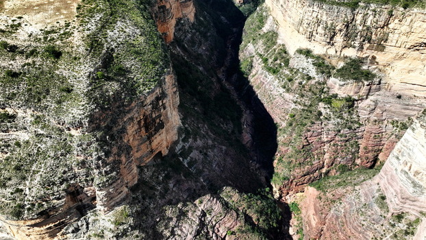 Aerial view of El Vergel canyon featuring deep rocky gorges layered geological formations and sparse vegetation in Torotoro Potosi Department Bolivia. Aerial view of El Vergel canyon featuring deep rocky gorges layered geological formations and sparse vegetation in Torotoro Potosi Department Bolivia.