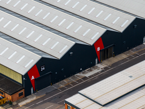 Aerial view of Ark Data Centres at Longcross Park featuring industrial buildings with metal roofs and red accents in Chertsey England United Kingdom. Aerial view of Ark Data Centres at Longcross Park featuring industrial buildings with metal roofs and red accents in Chertsey England United Kingdom.