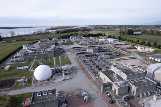 Aerial view of the Lulu Island Wastewater Treatment Plant with circular tanks a large white spherical gas storage tank and industrial infrastructure in Richmond British Columbia Canada. Aerial view of the Lulu Island Wastewater Treatment Plant with circular tanks a large white spherical gas storage tank and industrial infrastructure in Richmond British Columbia Canada.