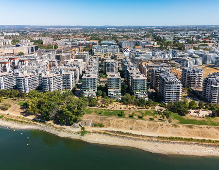 Aerial view of modern residential complexes and active construction along the Danube riverfront in Budapest Hungary with parks and dense urban neighborhoods. Aerial view of modern residential complexes and active construction along the Danube riverfront in Budapest Hungary with parks and dense urban neighborhoods.
