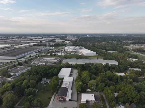 Aerial view of industrial warehouses commercial buildings and parking lots surrounded by green trees and a small pond in Indianapolis Indiana United States. Aerial view of industrial warehouses commercial buildings and parking lots surrounded by green trees and a small pond in Indianapolis Indiana United States.