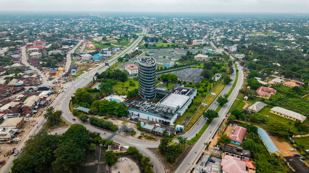 Aerial view of the cylindrical Ibom e Library building surrounded by urban roads green spaces and residential rooftops in Uyo Akwa Ibom Nigeria. Aerial view of the cylindrical Ibom e Library building surrounded by urban roads green spaces and residential rooftops in Uyo Akwa Ibom Nigeria.