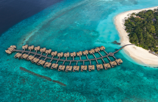 Aerial view of luxury overwater bungalows arranged in a curved line over turquoise coral reefs and a white sand beach at Hoarafushi Haa Alif Atoll Maldives. Aerial view of luxury overwater bungalows arranged in a curved line over turquoise coral reefs and a white sand beach at Hoarafushi Haa Alif Atoll Maldives.