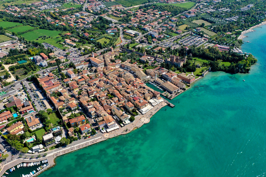 Aerial view of the historic town of Lazise on the shores of Lake Garda featuring the Scaligero Castle terracotta rooftops and turquoise waters Italy. Aerial view of the historic town of Lazise on the shores of Lake Garda featuring the Scaligero Castle terracotta rooftops and turquoise waters Italy.