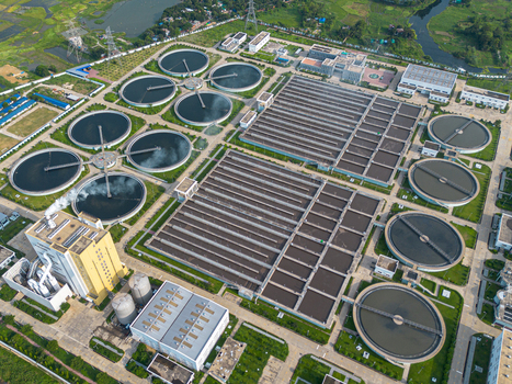 Aerial view of the Sewage Treatment Plant Dhaka WASA featuring circular clarifiers and rectangular aeration tanks surrounded by greenery in Dhaka Dhaka Division Bangladesh. Aerial view of the Sewage Treatment Plant Dhaka WASA featuring circular clarifiers and rectangular aeration tanks surrounded by greenery in Dhaka Dhaka Division Bangladesh.