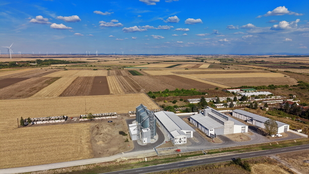 Aerial view of the storage silo Bavaniste facility surrounded by vast agricultural fields under a clear blue sky in Bavaniste Vojvodina Serbia.