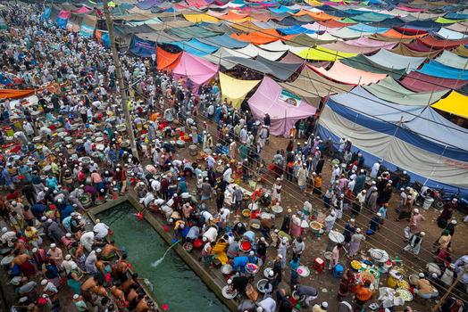 Tongi Bangladesh 31 January 2025 Aerial view of the Tongi Ijtema Maidan filled with a large crowd of people under colorful tents near a water channel during the Bishwa Ijtema.