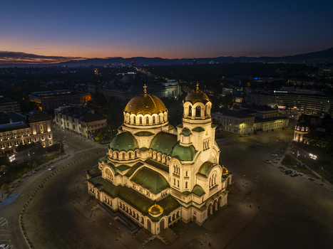 Aerial view of Patriarchal Cathedral St. Alexander Nevsky illuminated at twilight with golden domes and green roofs in Sofia Sofia City Province Bulgaria. Aerial view of Patriarchal Cathedral St. Alexander Nevsky illuminated at twilight with golden domes and green roofs in Sofia Sofia City Province Bulgaria.