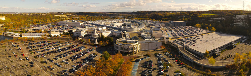 Aerial view of the Bluewater Shopping Centre surrounded by extensive parking lots and autumn foliage in Dartford England United Kingdom.