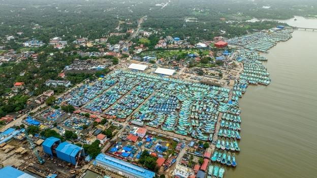 Aerial view of Malpe Fishing Harbour with hundreds of colorful fishing boats docked in the harbor surrounded by coastal infrastructure and lush greenery in Udupi Karnataka India. Aerial view of Malpe Fishing Harbour with hundreds of colorful fishing boats docked in the harbor surrounded by coastal infrastructure and lush greenery in Udupi Karnataka India.