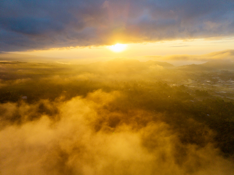 Aerial view of Sumberurip landscape at sunrise with golden light illuminating the mist and rolling hills in Pronojiwo East Java Indonesia. Aerial view of Sumberurip landscape at sunrise with golden light illuminating the mist and rolling hills in Pronojiwo East Java Indonesia.
