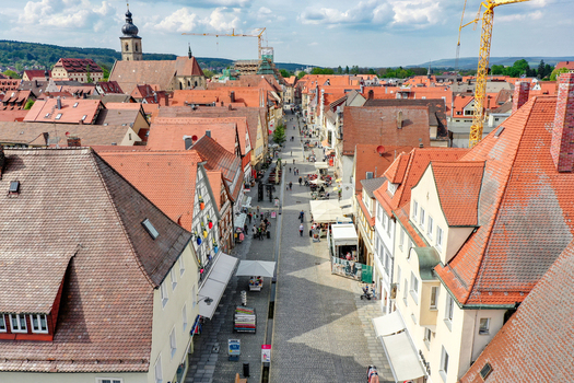 Aerial view of Hauptstrasse with historic half timbered houses red tiled roofs and people walking in the old town of Forchheim Bayern Germany.