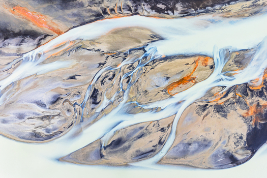 Aerial view of a glacial braided river with white water channels and dark volcanic sediment in Iceland. Aerial view of a glacial braided river with white water channels and dark volcanic sediment in Iceland.