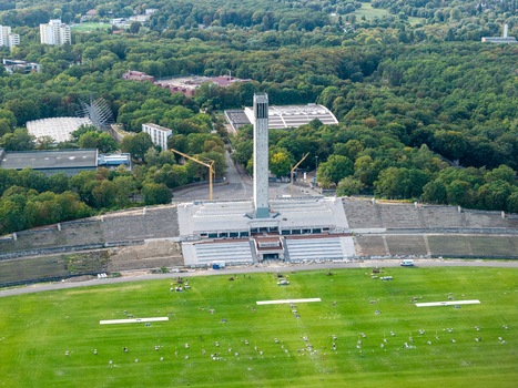 Berlin Germany 26 September 2026 Aerial view of the Olympiastadion Berlin showing the iconic bell tower the vast green field and surrounding lush forest parkland.