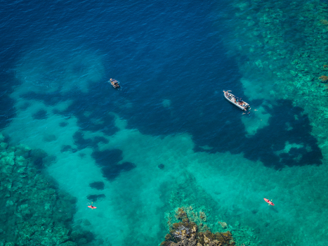 Aerial view of boats and kayaks floating on the crystal clear turquoise waters of Aquarium Beach near Jala Vlore County Albania. Aerial view of boats and kayaks floating on the crystal clear turquoise waters of Aquarium Beach near Jala Vlore County Albania.