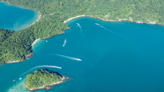Aerial view of Lagoa Azul also known as Blue Lagoon featuring turquoise waters lush green islands and boats leaving wakes in Angra dos Reis Rio de Janeiro Brazil.
