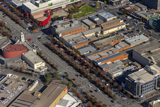 Aerial view of the urban landscape and commercial buildings along Lonsdale Street with parking lots and autumn trees in Dandenong Victoria Australia.