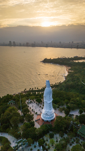 Aerial view of the Lady Buddha statue at Linh Ung Pagoda overlooking the coastline and city skyline of Da Nang Vietnam. Aerial view of the Lady Buddha statue at Linh Ung Pagoda overlooking the coastline and city skyline of Da Nang Vietnam.