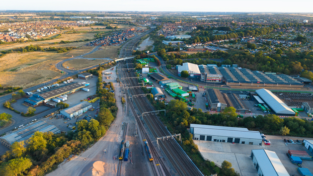 Aerial view of Wellingborough sidings freight terminal with railway tracks industrial warehouses and storage facilities under sunset light in Wellingborough England United Kingdom. Aerial view of Wellingborough sidings freight terminal with railway tracks industrial warehouses and storage facilities under sunset light in Wellingborough England United Kingdom.