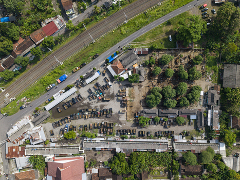 Aerial view of Animal Market Prambanan with trucks parked in the lot a railway track and surrounding trees in Kecamatan Prambanan Jawa Tengah Indonesia. Aerial view of Animal Market Prambanan with trucks parked in the lot a railway track and surrounding trees in Kecamatan Prambanan Jawa Tengah Indonesia.