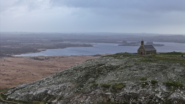 Aerial view of the Mont Saint Michel de Brasparts chapel on a rocky hilltop overlooking Lac de Brennilis and the surrounding moorland landscape Saint Rivoal Bretagne France. Aerial view of the Mont Saint Michel de Brasparts chapel on a rocky hilltop overlooking Lac de Brennilis and the surrounding moorland landscape Saint Rivoal Bretagne France.