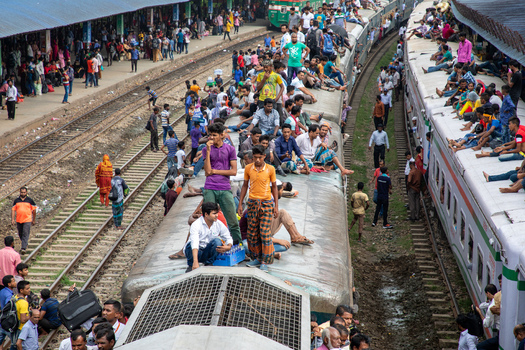 Dhaka Bangladesh 14 June 2018 View of Airport Railway Station with many people sitting on the roofs of trains and waiting on the platforms. Dhaka Bangladesh 14 June 2018 View of Airport Railway Station with many people sitting on the roofs of trains and waiting on the platforms.