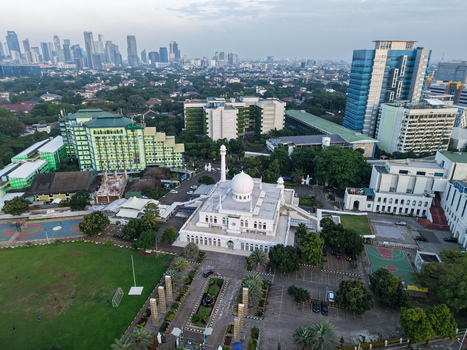 Aerial view of Al Azhar Great Mosque surrounded by lush greenery modern buildings and urban infrastructure in Kecamatan Kebayoran Baru Daerah Khusus Ibukota Indonesia.