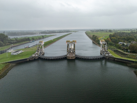 Aerial view of Sluis en stuwcomplex Hagestein a large lock and weir complex on the Lek River surrounded by green banks and agricultural fields in Hagestein Utrecht Netherlands.