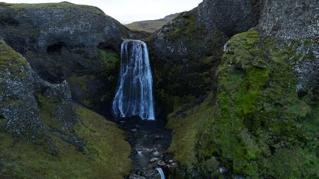 Aerial view of Bugsfoss waterfall and mossy cliffs Iceland.