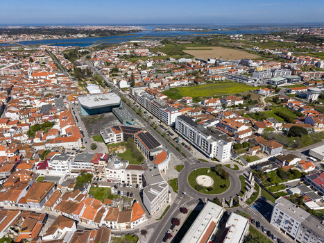 Aerial view of terracotta rooftops meeting modern buildings and a roundabout near the Tagus River s mouth Vila Franca de Xira Portugal. Aerial view of terracotta rooftops meeting modern buildings and a roundabout near the Tagus River s mouth Vila Franca de Xira Portugal.