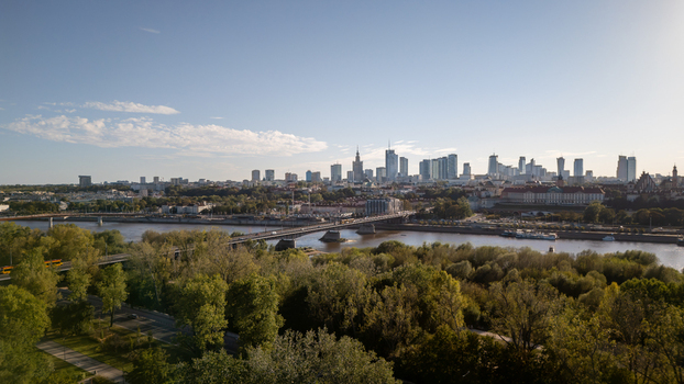 Aerial view of the Vistula River flowing past the lush greenery of Park Praski towards the gleaming skyscrapers of the city skyline Warsaw Poland. Aerial view of the Vistula River flowing past the lush greenery of Park Praski towards the gleaming skyscrapers of the city skyline Warsaw Poland.