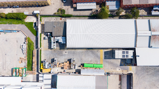 Aerial view of a waste processing facility with industrial buildings storage containers and pallets in a concrete yard in Milan Lombardy Italy. Aerial view of a waste processing facility with industrial buildings storage containers and pallets in a concrete yard in Milan Lombardy Italy.
