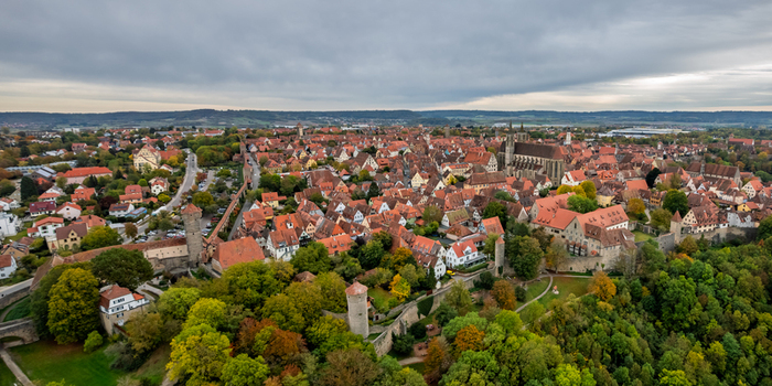 Aerial view of the historic medieval town of Rothenburg ob der Tauber with red tiled rooftops ancient defensive walls and lush greenery in Rothenburg ob der Tauber Bavaria Germany.