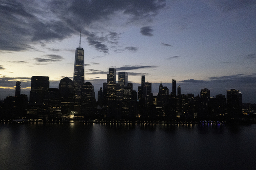Aerial view of the New York skyline at dusk featuring One World Trade Center and illuminated skyscrapers reflecting over the Hudson River New York New York United States.