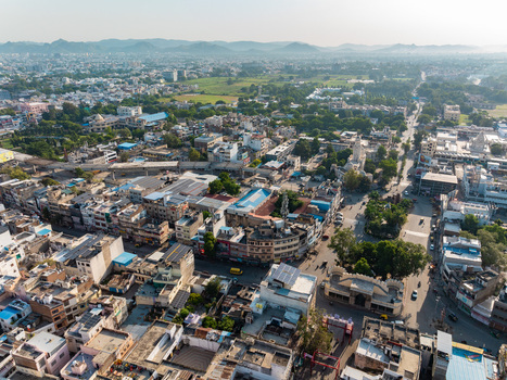 Aerial view of the city with dense urban architecture rooftops streets and surrounding hills in Udaipur Rajasthan India.