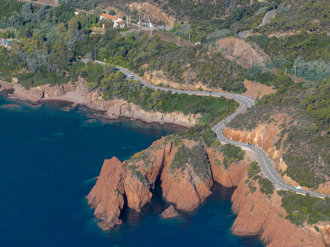 Aerial view of Le Trayas featuring the winding coastal road along the red rock cliffs of the Esterel Massif overlooking the Mediterranean Sea in Saint Raphael Provence Alpes Cote d Azur France. Aerial view of Le Trayas featuring the winding coastal road along the red rock cliffs of the Esterel Massif overlooking the Mediterranean Sea in Saint Raphael Provence Alpes Cote d Azur France.