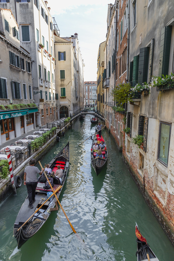 Venice Veneto Italy 21 September 2026 View of gondolas navigating a narrow canal lined with historic buildings and outdoor restaurant seating. Venice Veneto Italy 21 September 2026 View of gondolas navigating a narrow canal lined with historic buildings and outdoor restaurant seating.