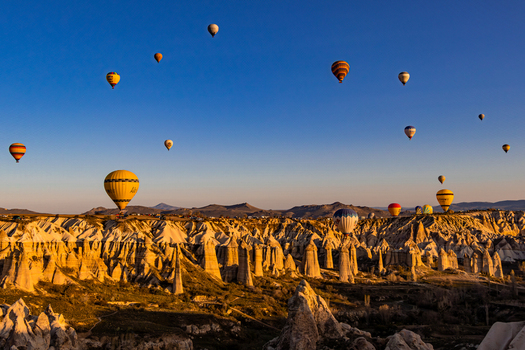 Goreme Nevsehir Turkiye 07 April 2025 Aerial view of hot air balloons floating over the unique rock formations and fairy chimneys of Cappadocia at sunrise. Goreme Nevsehir Turkiye 07 April 2025 Aerial view of hot air balloons floating over the unique rock formations and fairy chimneys of Cappadocia at sunrise.