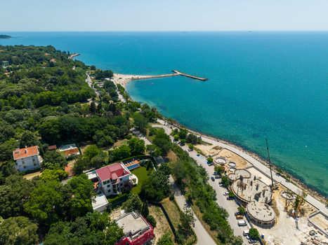 Aerial view of the Alley First promenade lush green trees a sandy beach a pier and ongoing construction work in Varna Varna Bulgaria. Aerial view of the Alley First promenade lush green trees a sandy beach a pier and ongoing construction work in Varna Varna Bulgaria.
